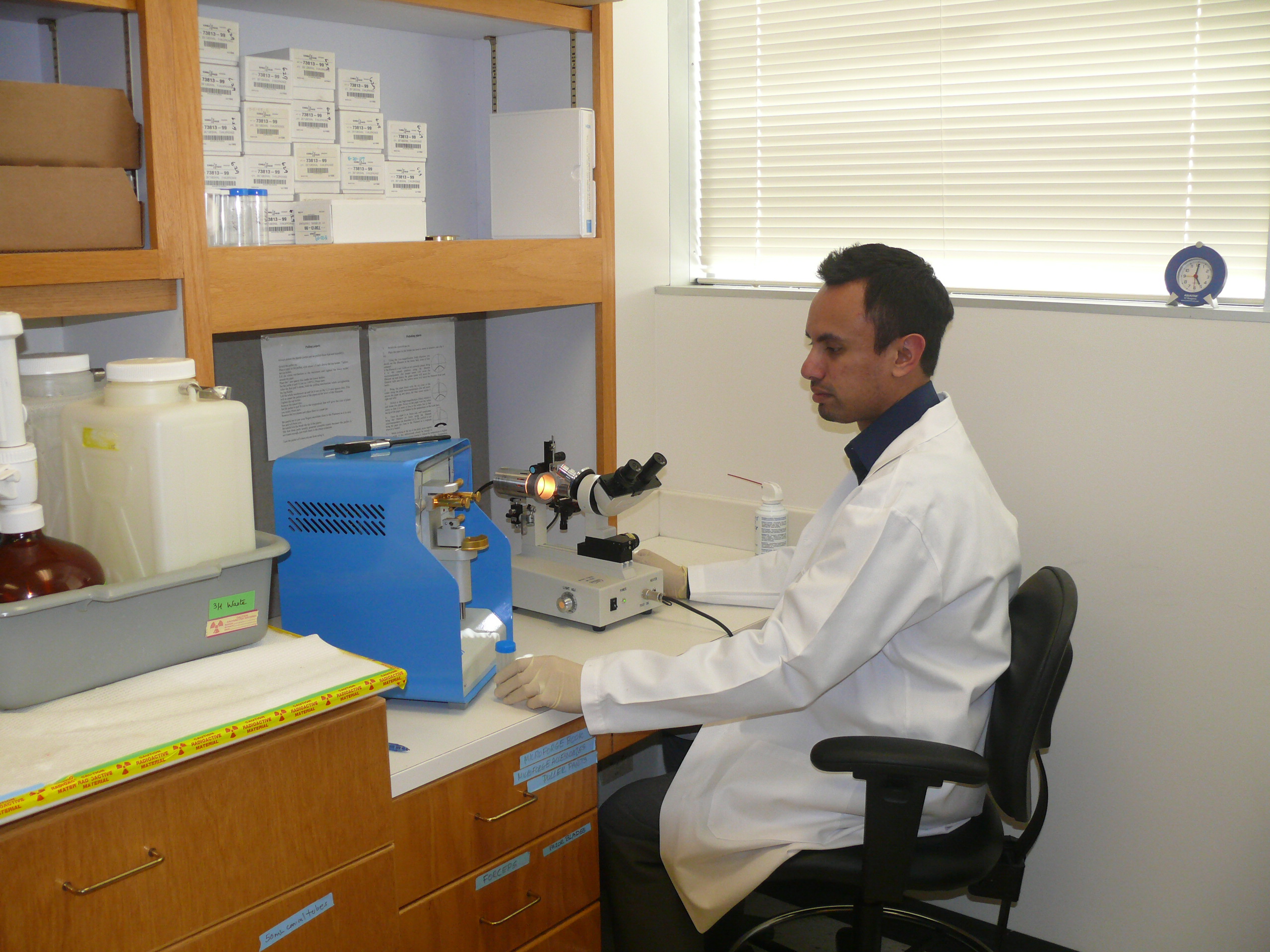 man sitting in a lab with a microscope