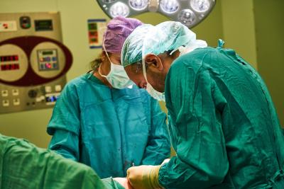 Photo of a surgeon slouching over the patient in the OR.