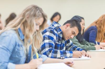 A few students studying carefully in a classroom.