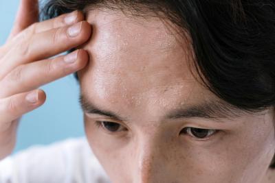 Close up photo of a man's forehead sweating