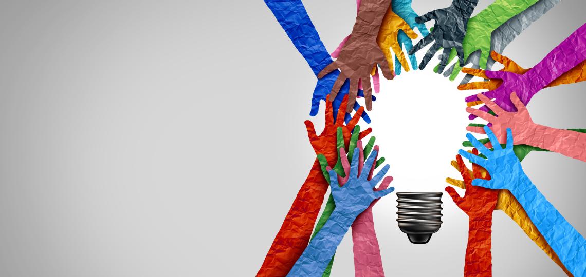 An illustration of several hands so different colors circling a light bulb graphic. 