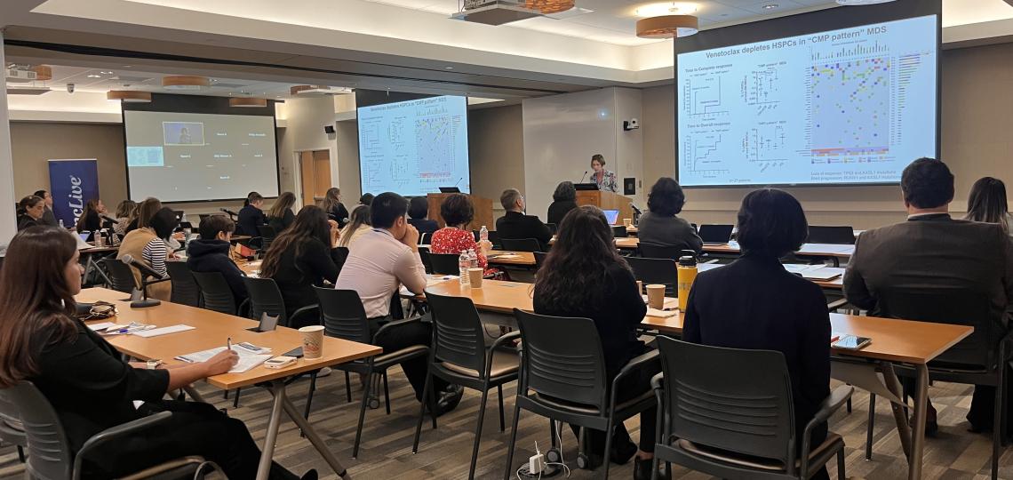 A group seated at tables watching a presentation