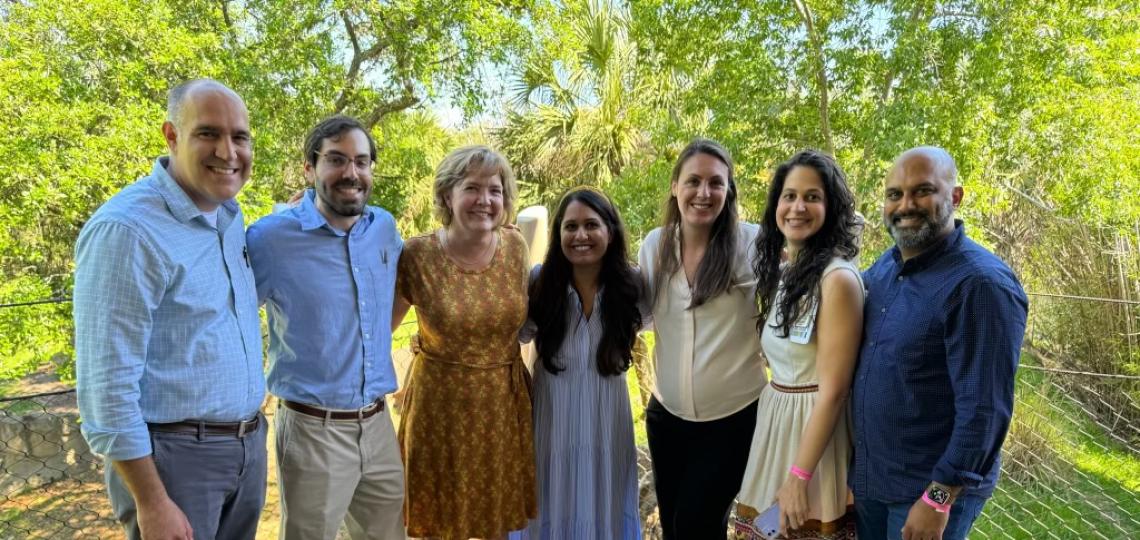 Seven people standing shoulder to shoulder outside
