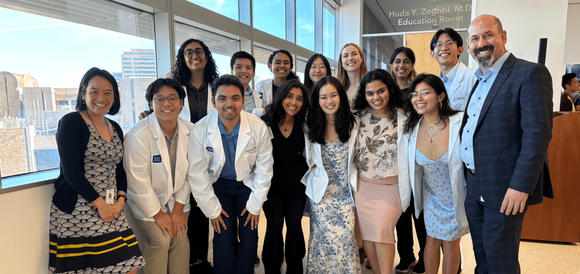 A group posting in front of a window, smiling