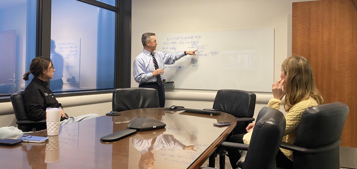 man pointing to writing on whiteboard