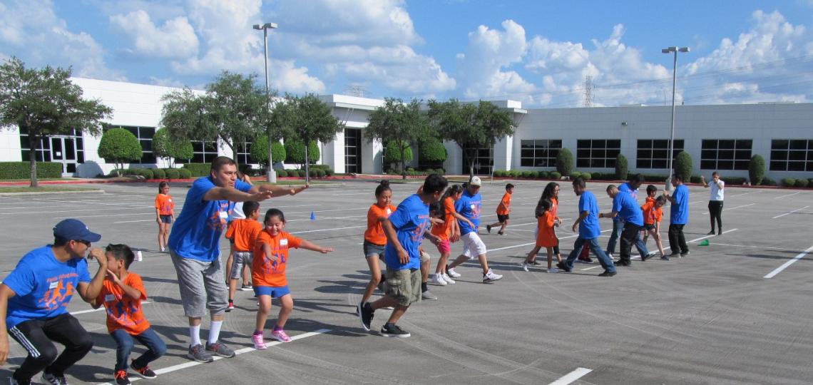 A group of parents and their children playing in outdoor games