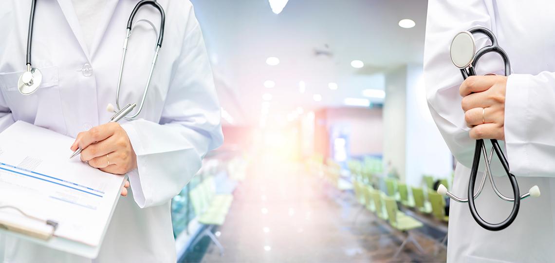 Female doctor's hand holding stethoscope and clipboard.