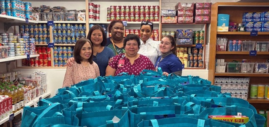 a group of people standing in a storeroom, surrounded by canned goods