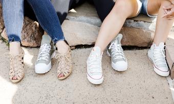 Three teens seated, focused on their shoes