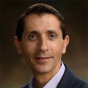 man smiling in front of grey background