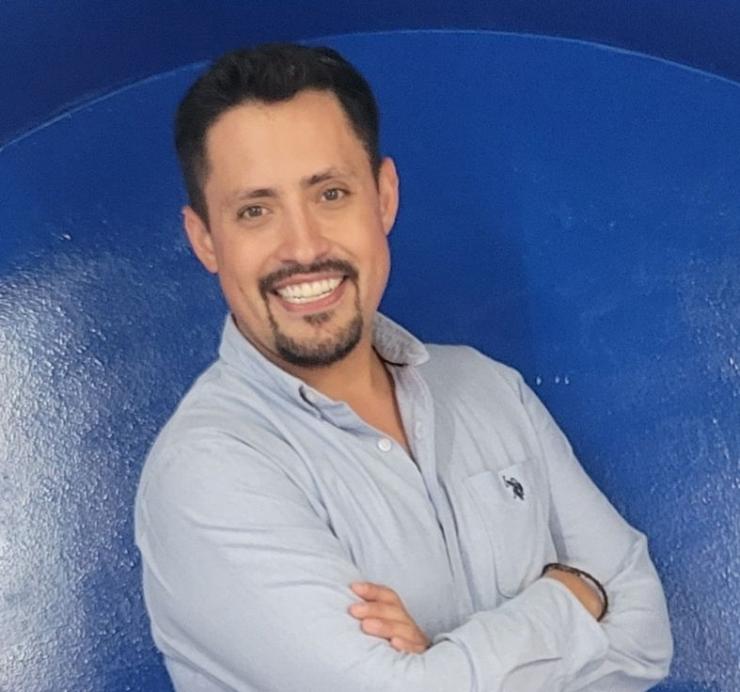 man smiling in front of a blue background