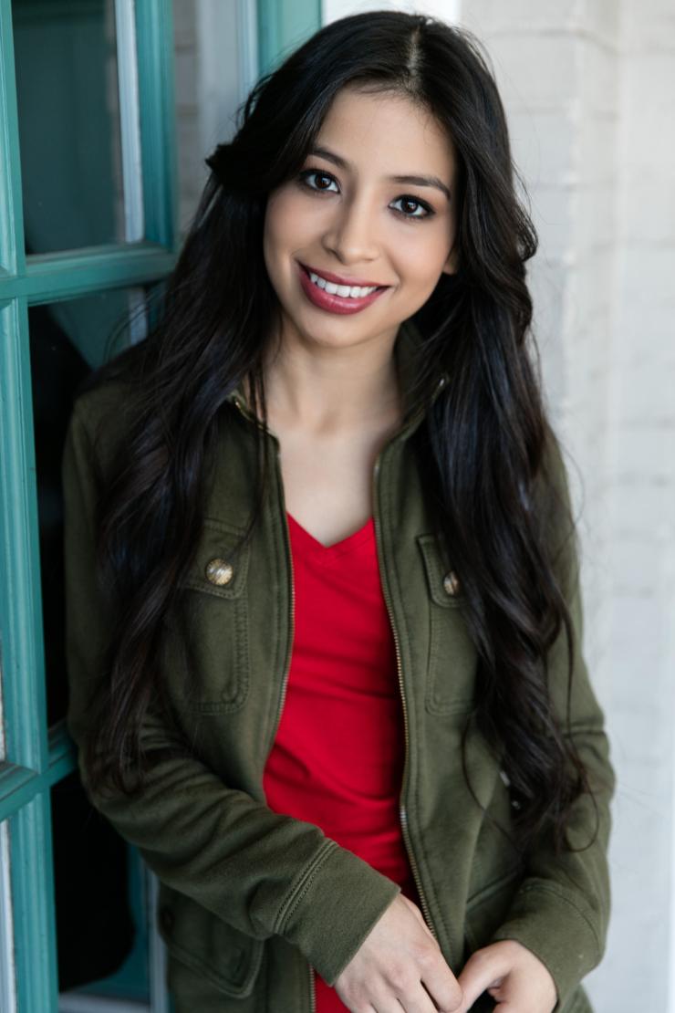 woman in a red shirt and long dark hair smiling