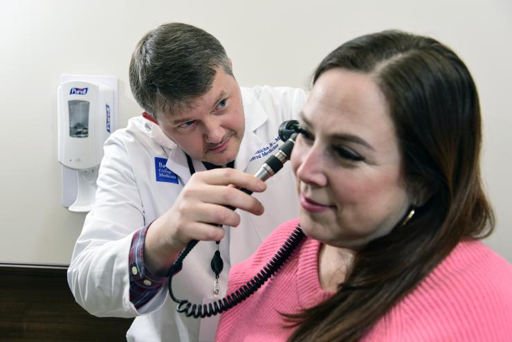 A doctor looking into a patient's ears.
