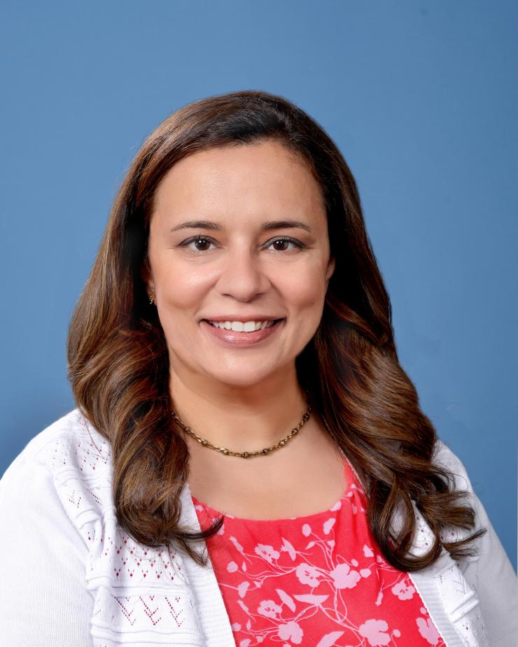 woman with lightly curled, brown hair smiling