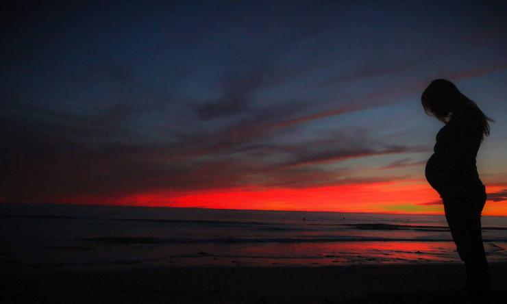 Pregnant woman at sunset