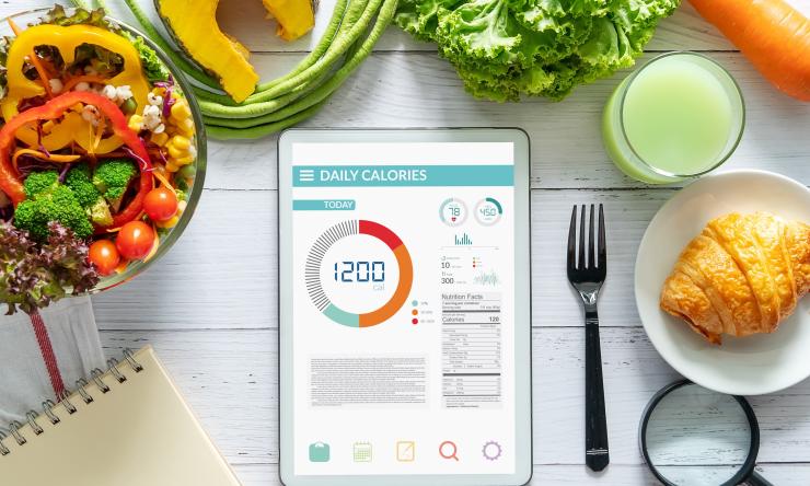 photo of electronic tablet surrounded by food