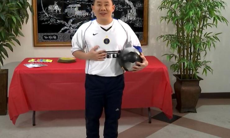 man standing and holding a helmet, smiling