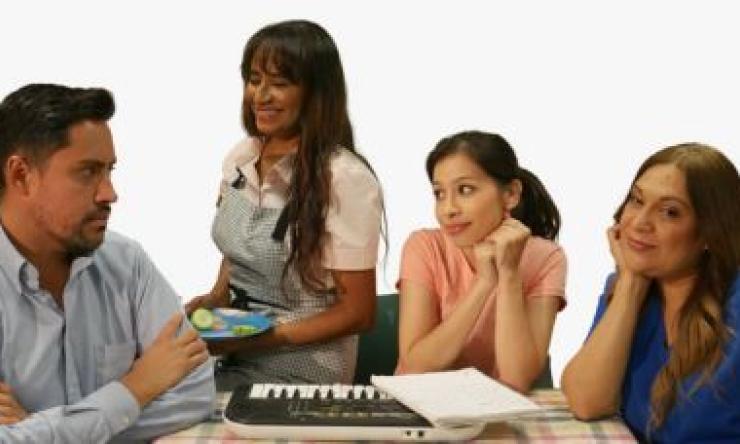 4 people sitting at a table talking and smiling