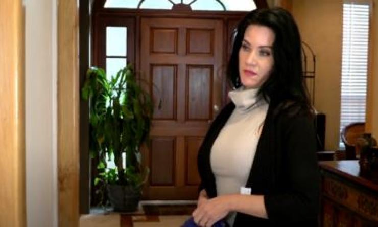 woman standing in front of a door with a concerned look on her face