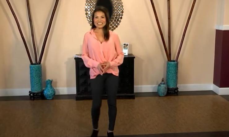 woman standing in a room with two large vases on the floor smiling